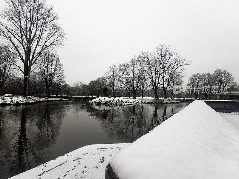 Water of the Südliche Düssel in the snow-covered Volksgarten in Düsseldorf